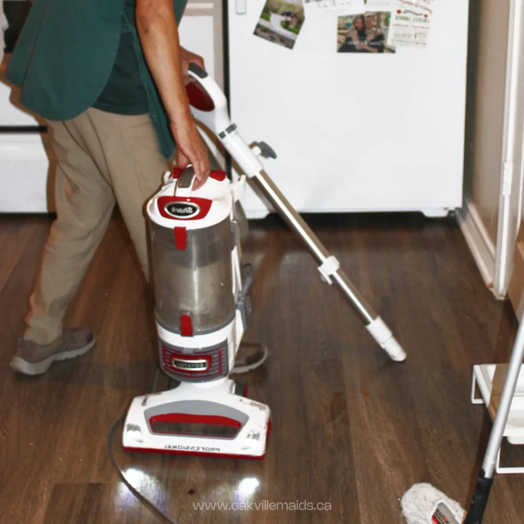 Professional house cleaner running a regular vacuum cleaner 